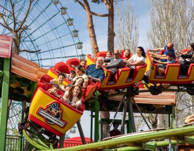 Des gens s'amusent sur des montagnes russes dans un parc d'attractions.