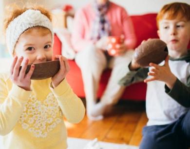 Bambini mangiano uova di cioccolato in soggiorno.