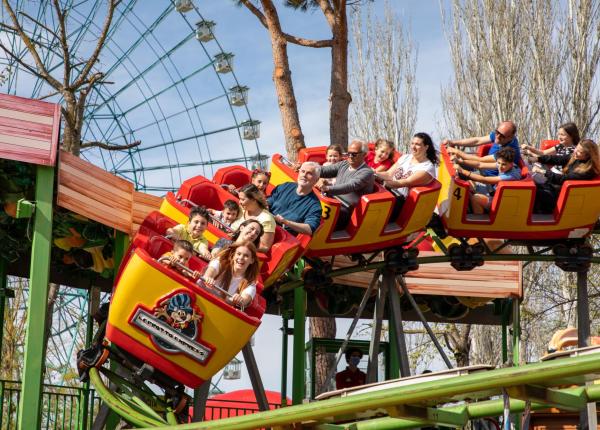 Des gens s'amusent sur des montagnes russes dans un parc d'attractions.